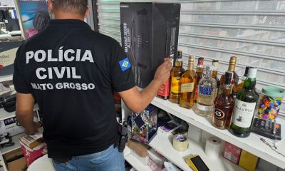Garrafas de bebidas destiladas com indícios de falsificação apreendidas durante operação da Polícia Civil no Shopping Popular de Cuiabá.