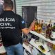 Garrafas de bebidas destiladas com indícios de falsificação apreendidas durante operação da Polícia Civil no Shopping Popular de Cuiabá.