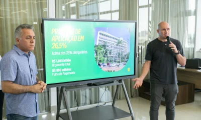 Prefeito Abilio Brunini em coletiva diante do painel da Prefeitura de Cuiabá; foto de arquivo ilustra texto sobre educação