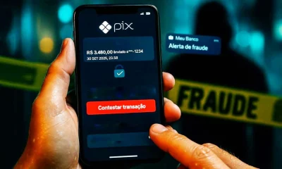 Celular mostra tela de contestação do MED Pix com botão vermelho; ao fundo, silhueta desfocada e fita amarela de fraude