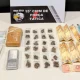 Tablete e porções de maconha, balança de precisão e cédulas de dinheiro sobre uma mesa, diante de placa da 15ª CIPM de Força Tática